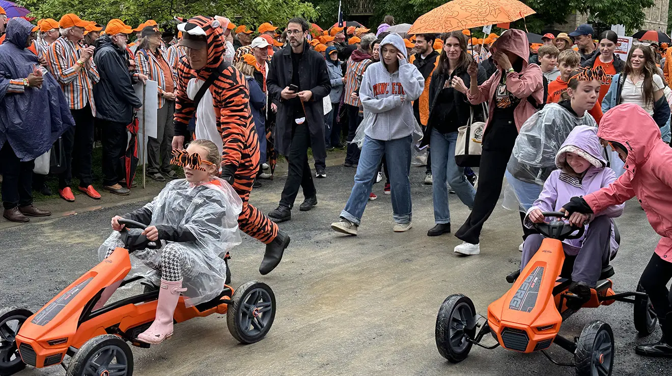 JulieReunions3_cropped.jpg Marching in the P-rade are two kids driving orange go-karts.
