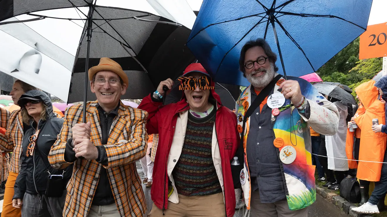PRADE_Three Fun Guys_Kevin Birch.jpg People smile from under umbrellas at the P-rade.
